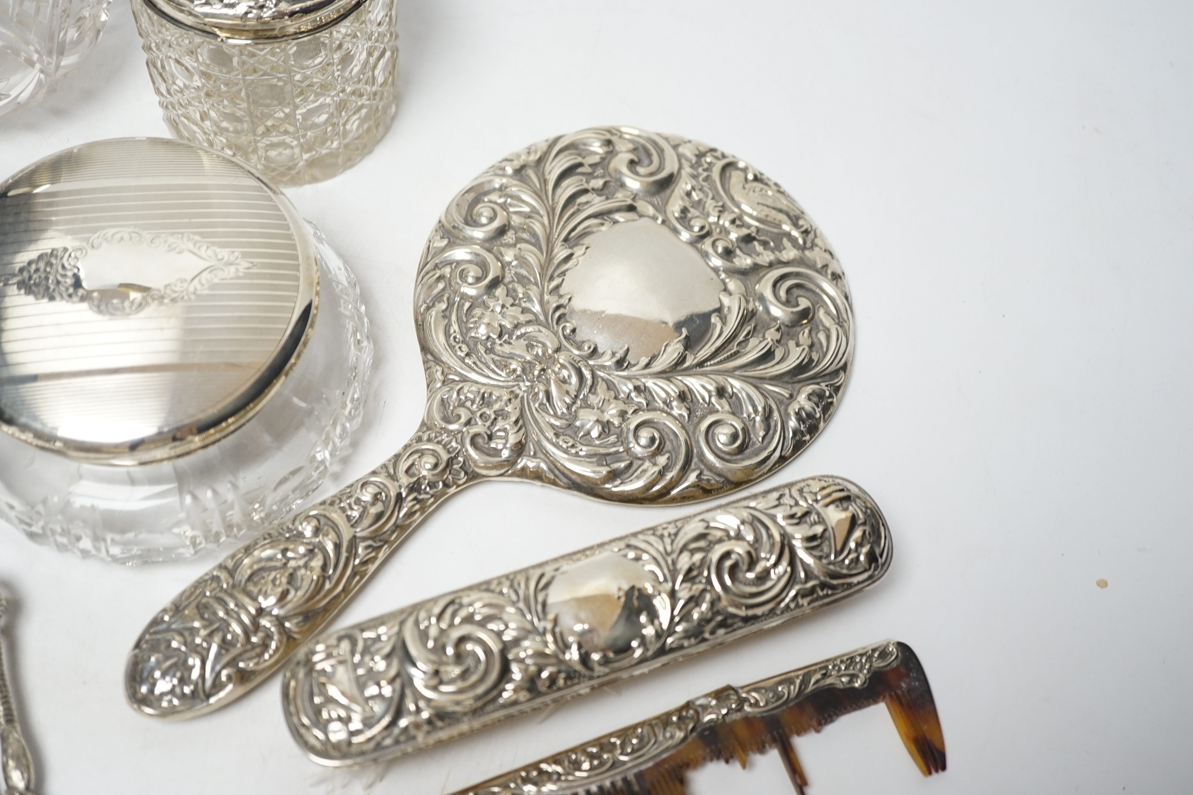 Seven assorted silver mounted glass scent bottles or toilet jars, and a repousse silver backed four piece dressing table set (a.f.) and other items including plated coffee spoons, place setting holders, etc.
